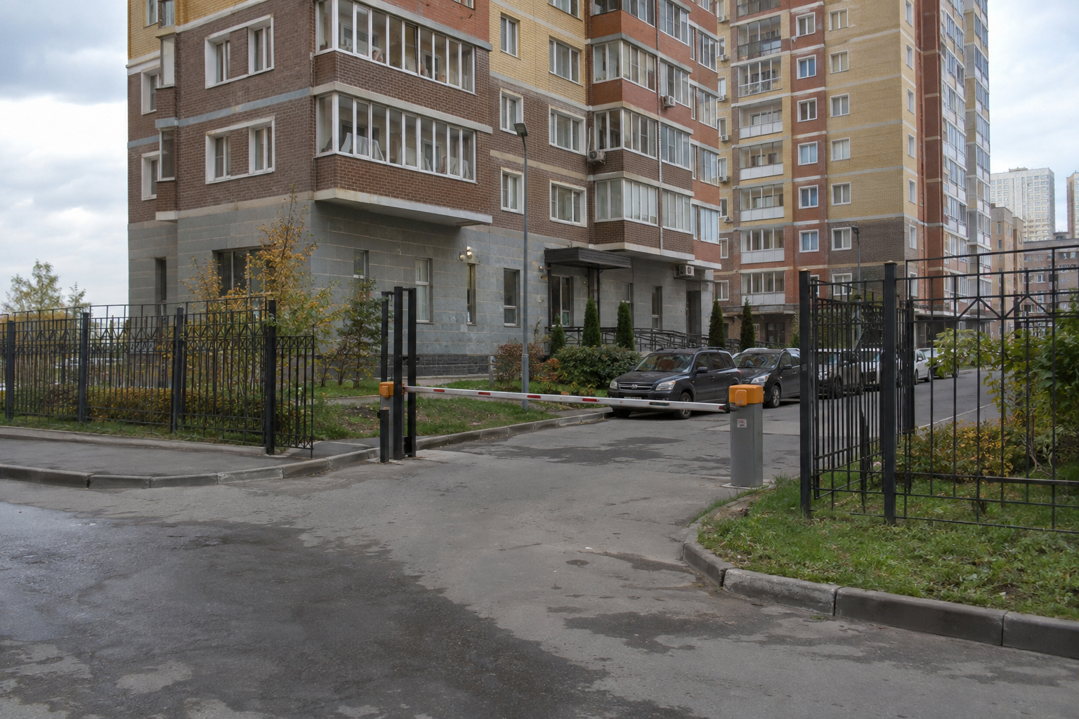 Автоматический шлагбаум с металлическим сварным ограждением периметра у жилого дома
